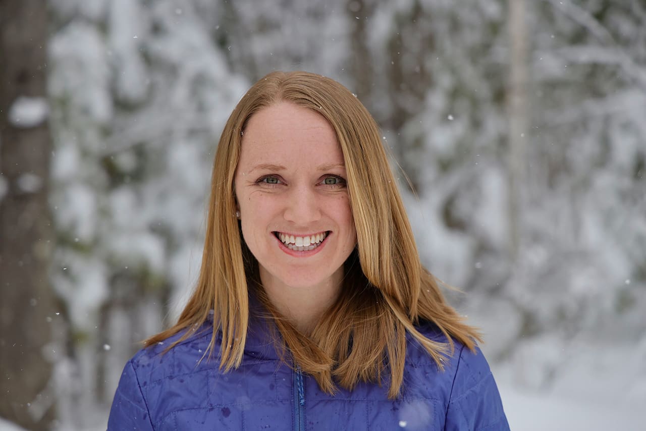 Vermont Dietitian, Jen Meijer, stands in a purple coat, smiling at the camera.