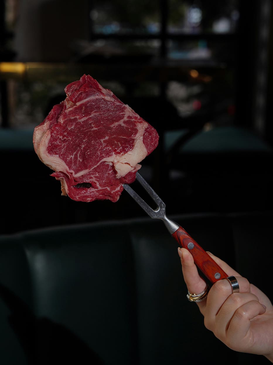 A large piece of steak on a fork.