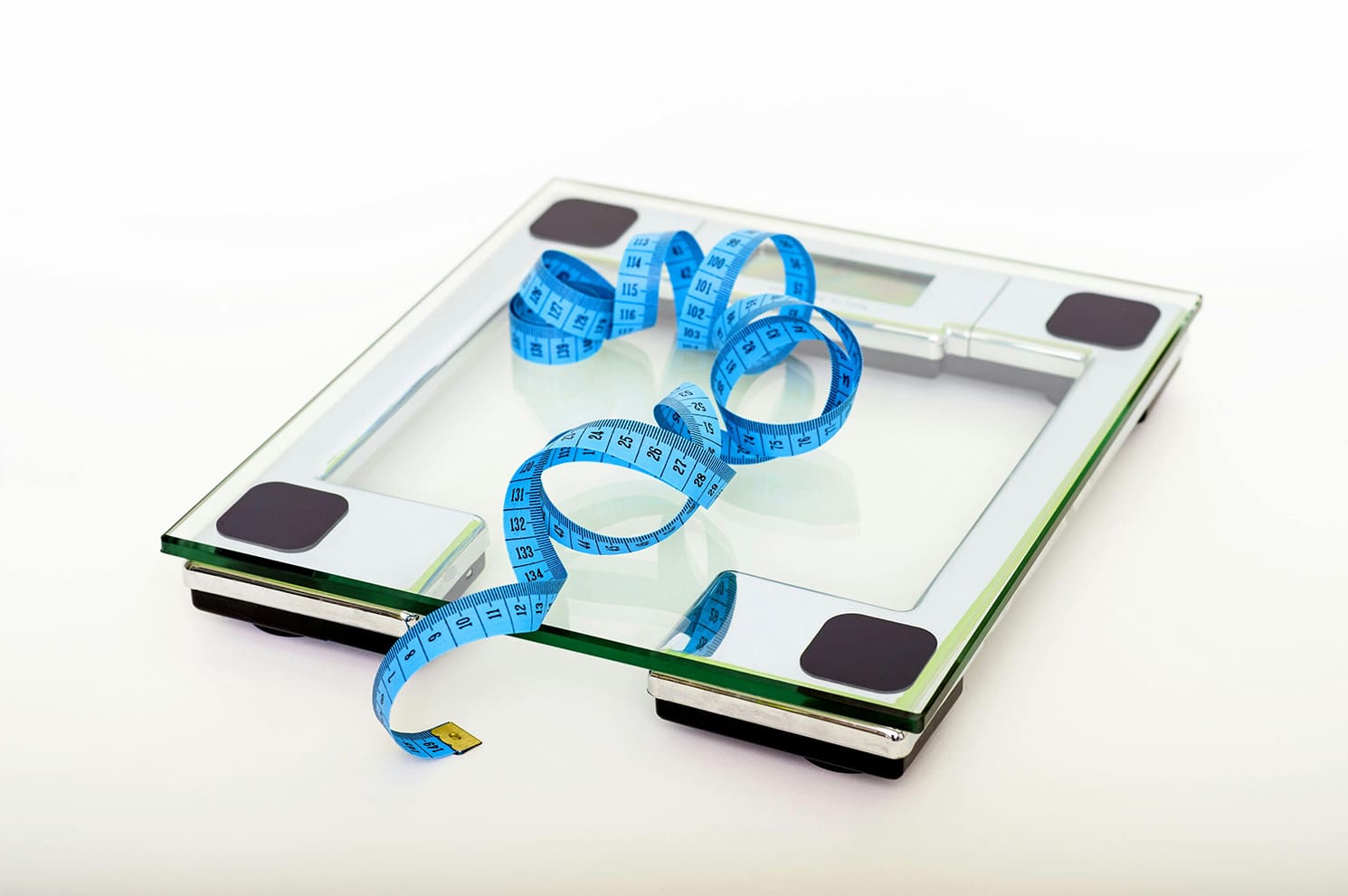 A scale displaying a measuring tape coiled beside it, indicating a focus on weight and measurement.